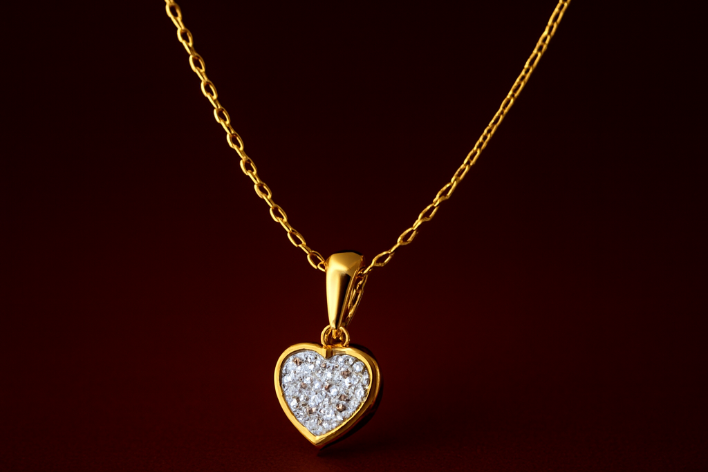Gold necklace with a heart-shaped pendant on a dark background